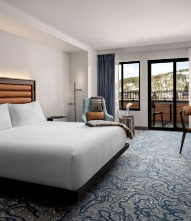 King guest room with balcony and mountain views at Hotel Alpenrock.
