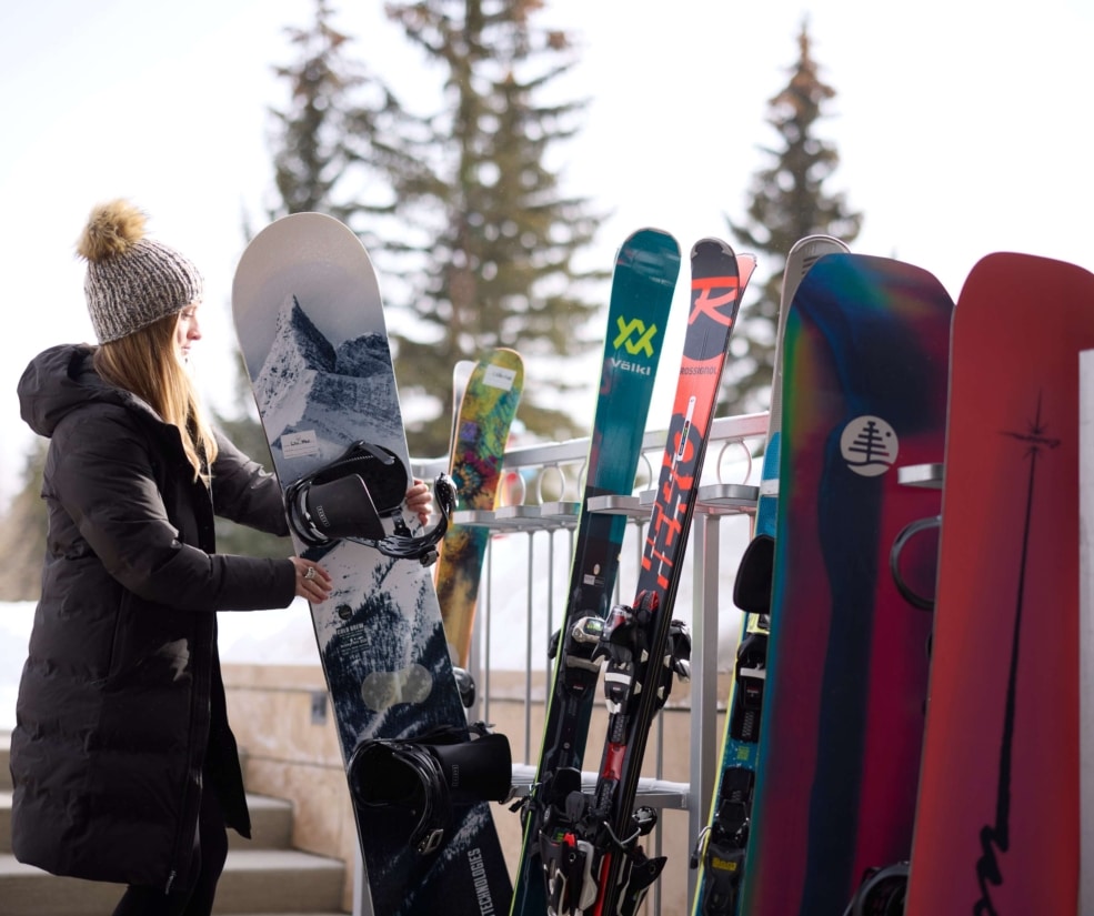 Guest storing a snowboard at the ski valet area of Hotel Alpenrock.