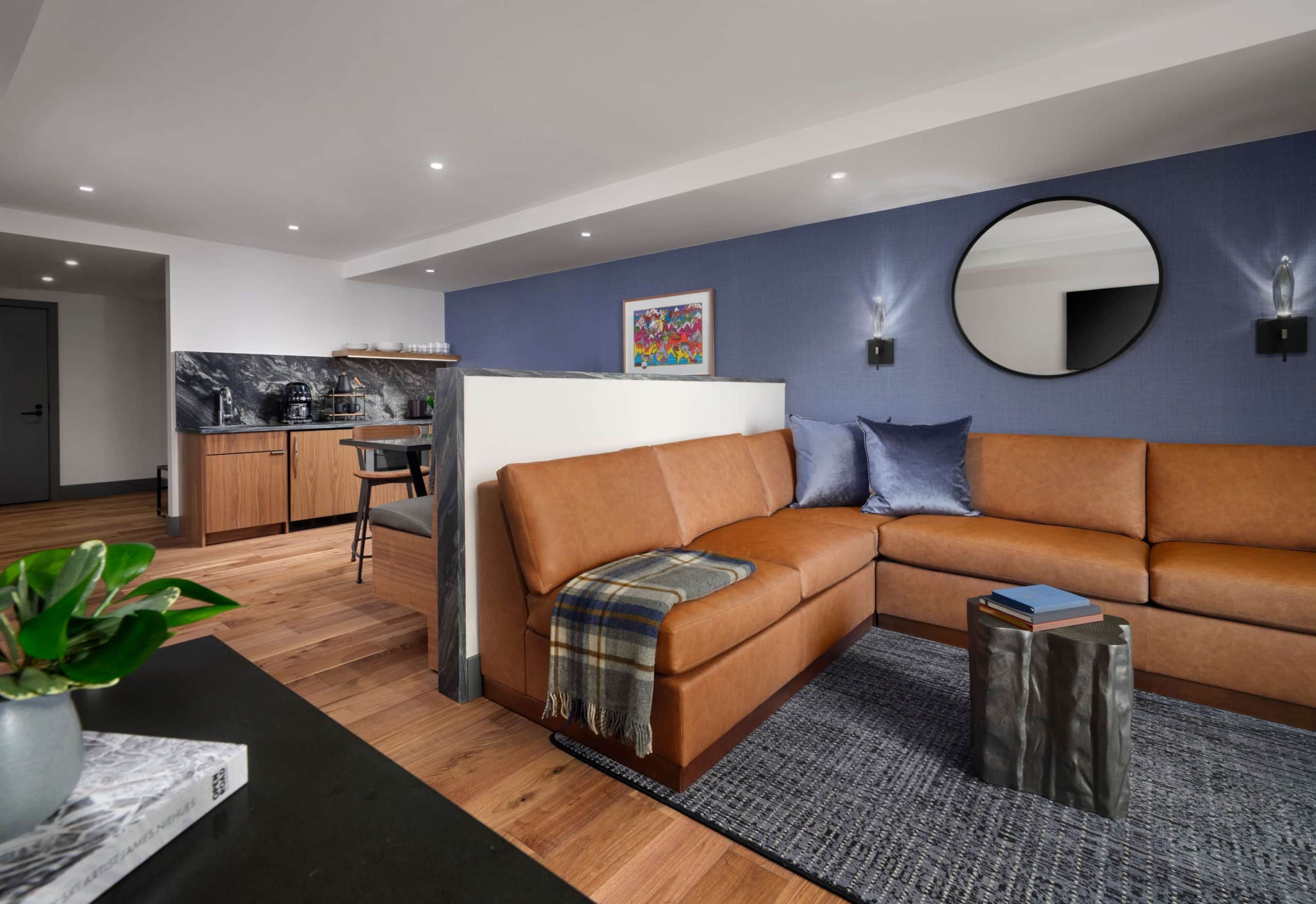 Hotel Alpenrock one-bedroom suite with leather sectional sofa, modern kitchenette, and open living space.