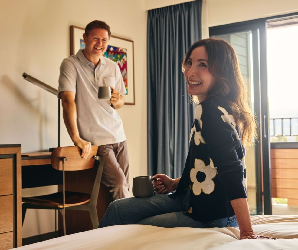 Couple relaxing with coffee inside a Hotel Alpenrock guest room.