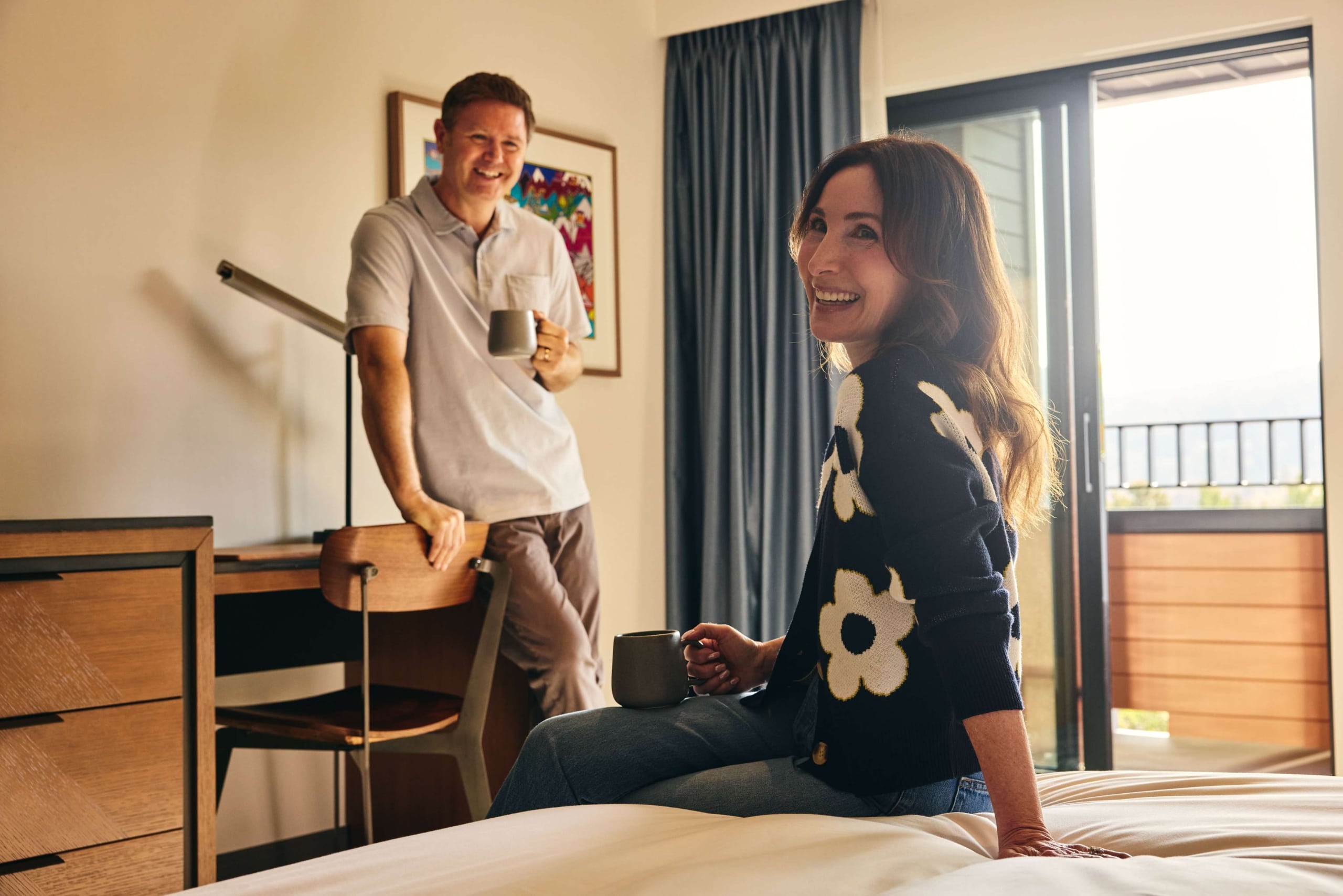 Couple relaxing with coffee inside a Hotel Alpenrock guest room.