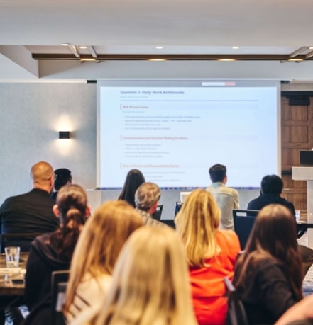 Professional conference presentation in the meeting room at Hotel Alpenrock with a speaker at the podium and engaged audience.