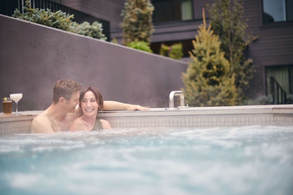 Couple relaxing in the outdoor hot tub at Hotel Alpenrock.
