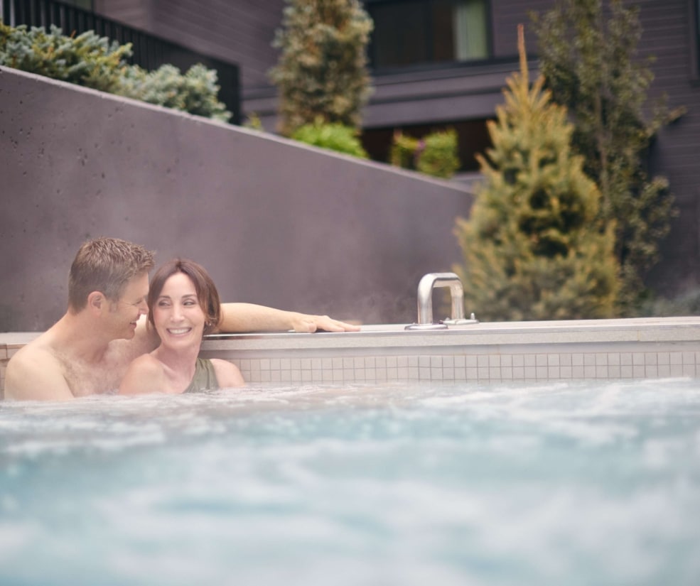 Couple relaxing in the outdoor hot tub at Hotel Alpenrock.