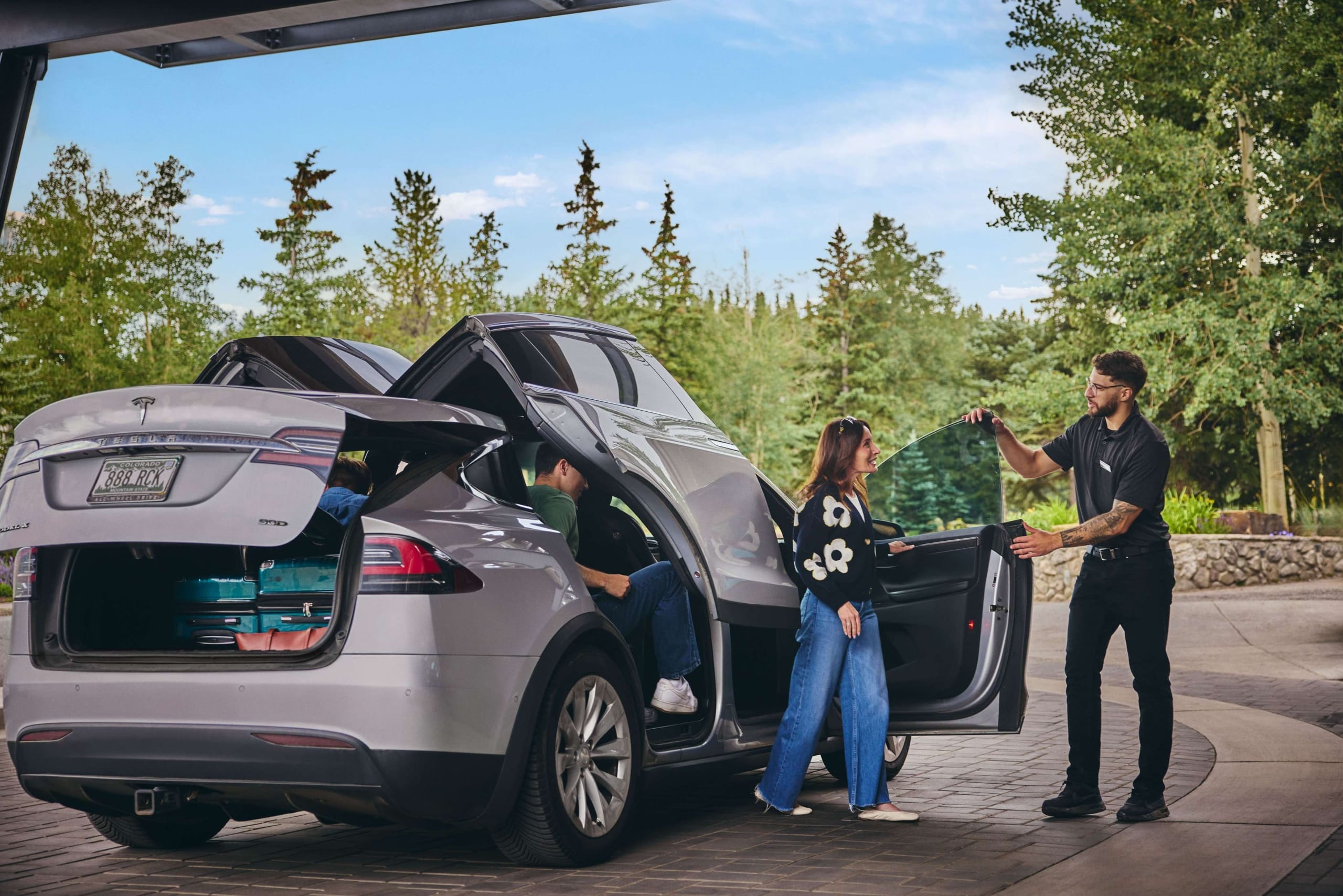 Valet assisting guests with luggage at the Hotel Alpenrock entrance.