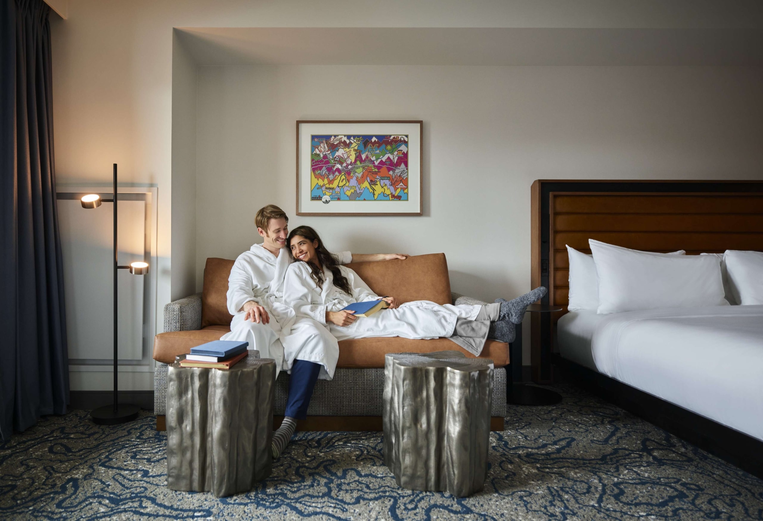Couple relaxing on a sofa in a Hotel Alpenrock guest room.