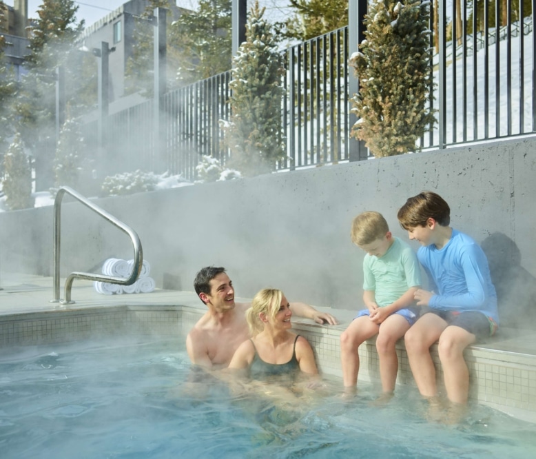 Family enjoying an outdoor hot tub at Hotel Alpenrock.