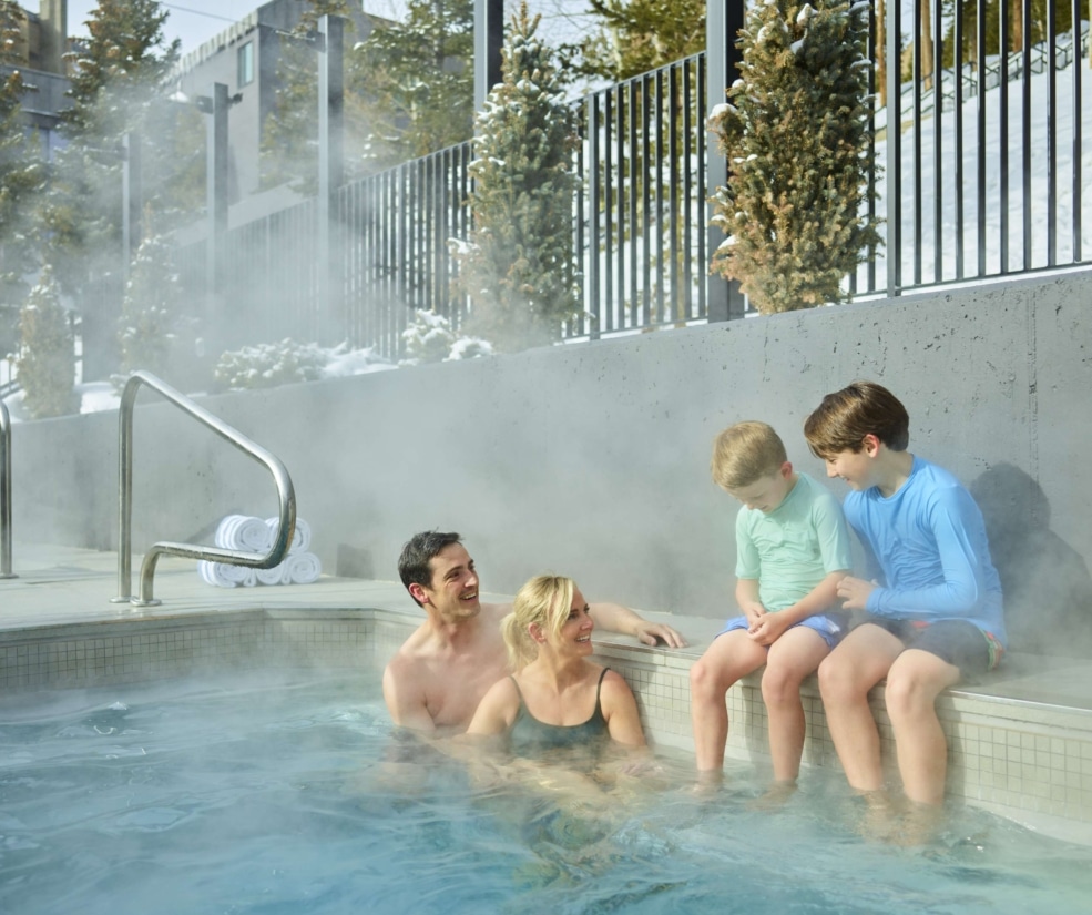 Family enjoying an outdoor hot tub at Hotel Alpenrock.