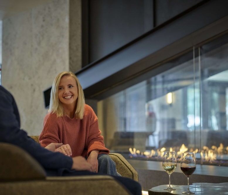 Guests relaxing by the fireplace in the Hotel Alpenrock lobby.