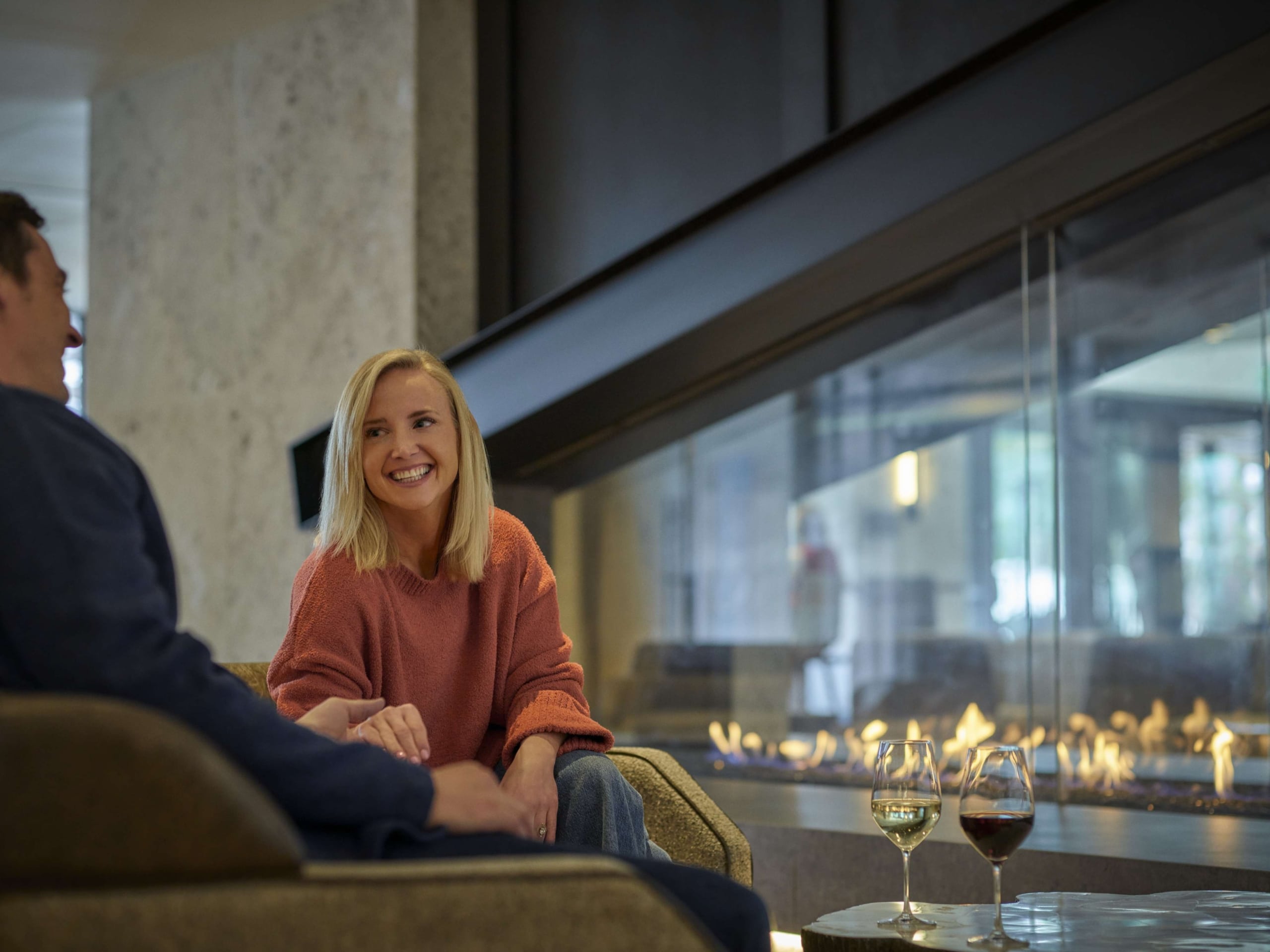 Guests relaxing by the fireplace in the Hotel Alpenrock lobby.