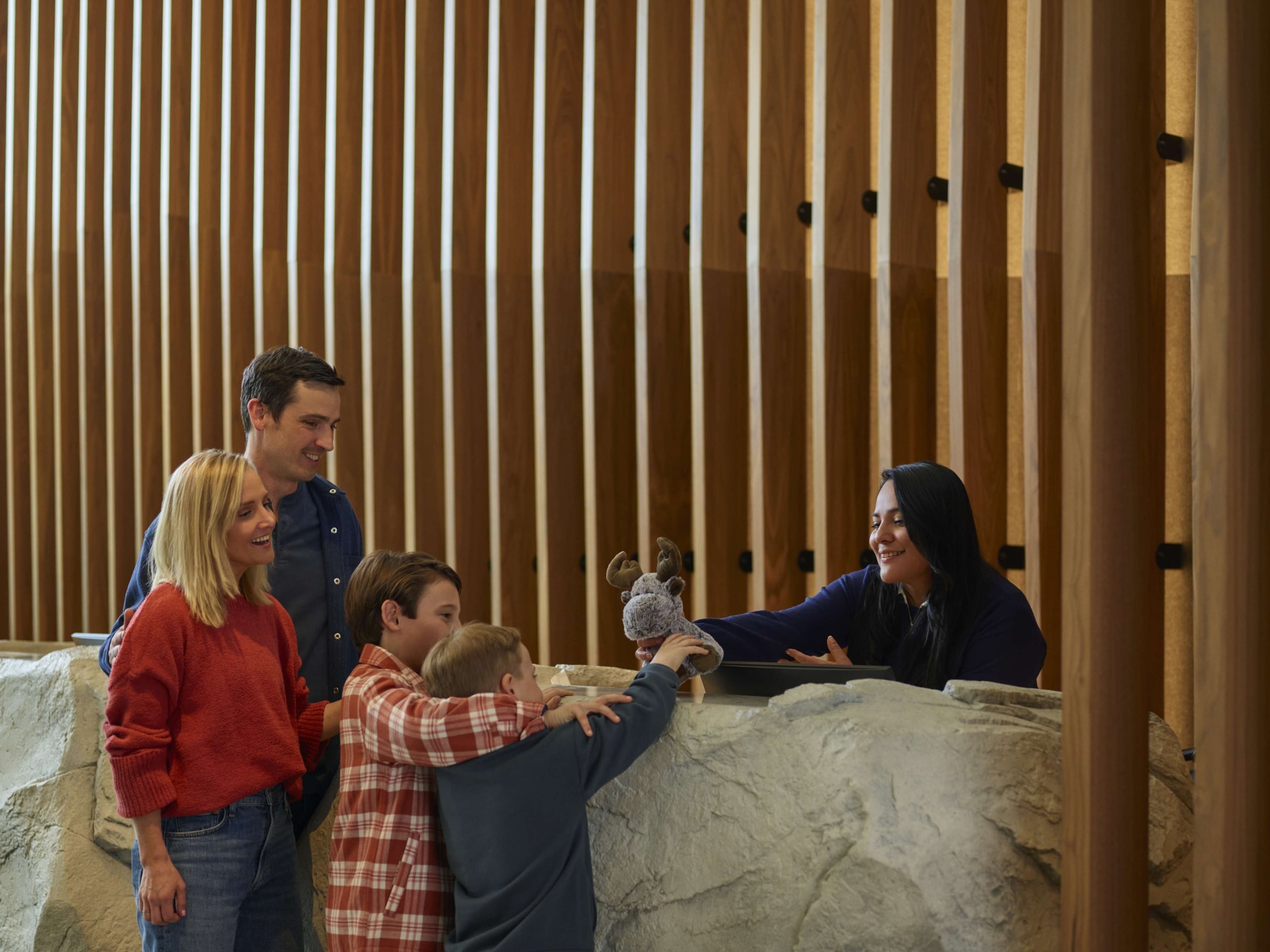 Family checking in with a front desk agent at Hotel Alpenrock.